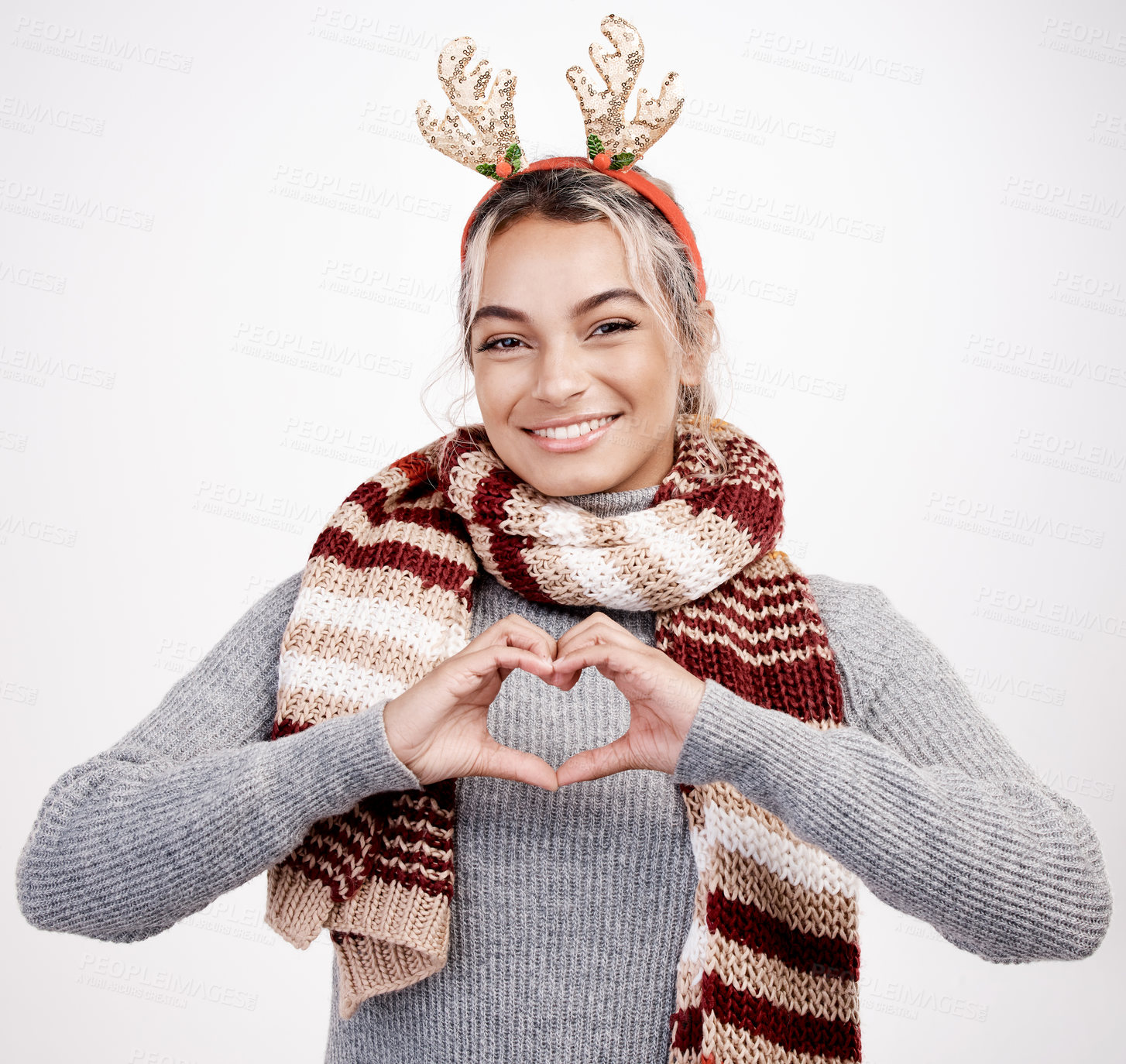 Buy stock photo Portrait, woman and heart with smile at Christmas for festive, winter and holiday on studio backdrop. Female person, cheerful and happy in celebration with shape for love in  season for vacation