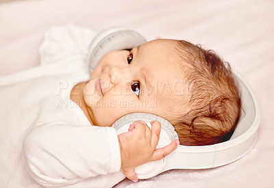 Buy stock photo Shot of a little baby lying down while wearing headphones
