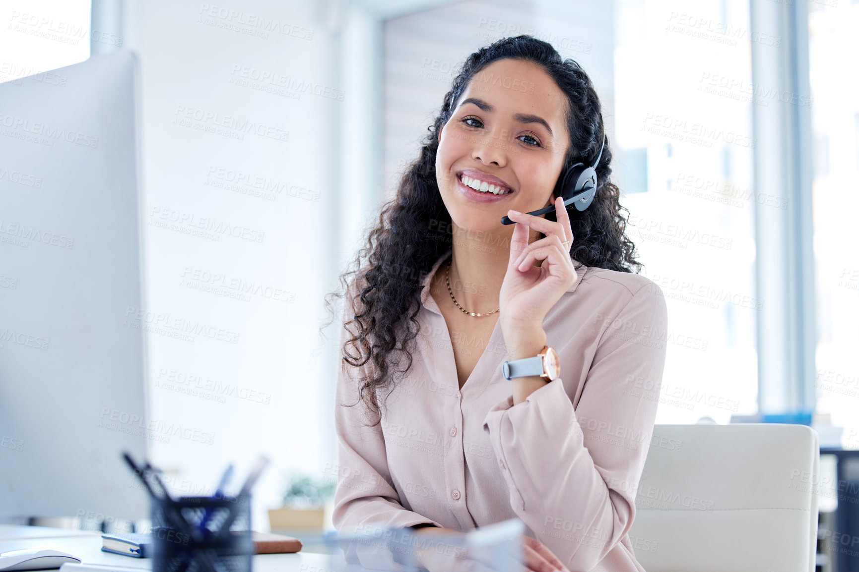 Buy stock photo Shot of an attractive young call centre agent sitting alone in her office during the day