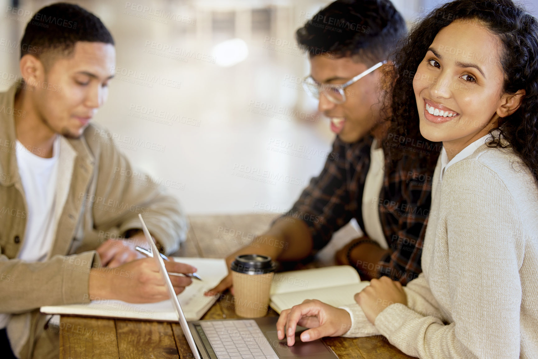 Buy stock photo Cropped portrait of an attractive young female college student studying in the library with two male classmates