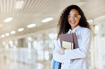 Buy stock photo Cropped portrait of an attractive young female science student standing with her textbooks in a campus hallway