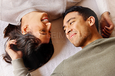 Buy stock photo Shot of a young couple laying on the floor at home