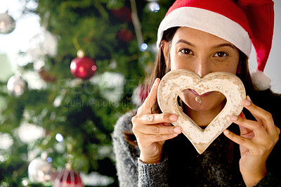 Buy stock photo Shot of a young woman holding Christmas decor at home