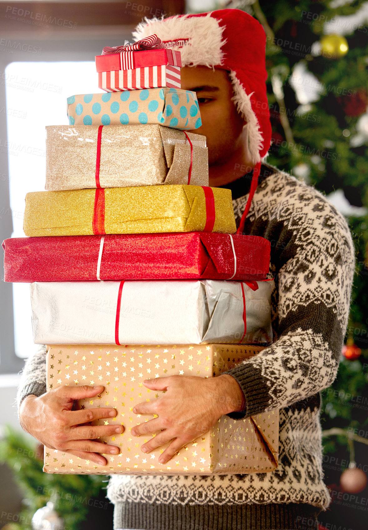 Buy stock photo Shot of a young man carrying a stack on gifts at home