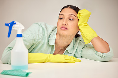 Buy stock photo Shot of a young woman sitting down after doing chores at home