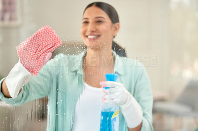 Buy stock photo Shot of a young woman cleaning the windows at home