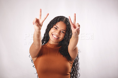 Buy stock photo Studio shot of a beautiful young woman showing the peace sign