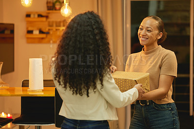 Buy stock photo Shot of a young woman giving her friend a birthday gift
