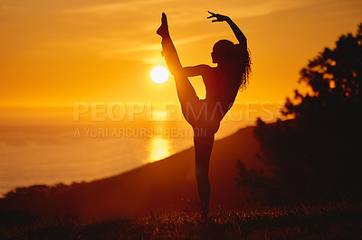 Buy stock photo Full length shot of an unrecognizable and athletic young woman practicing yoga outside at sunset