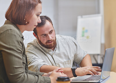 Buy stock photo Cropped shot of two corporate businesspeople working together on a laptop in their office