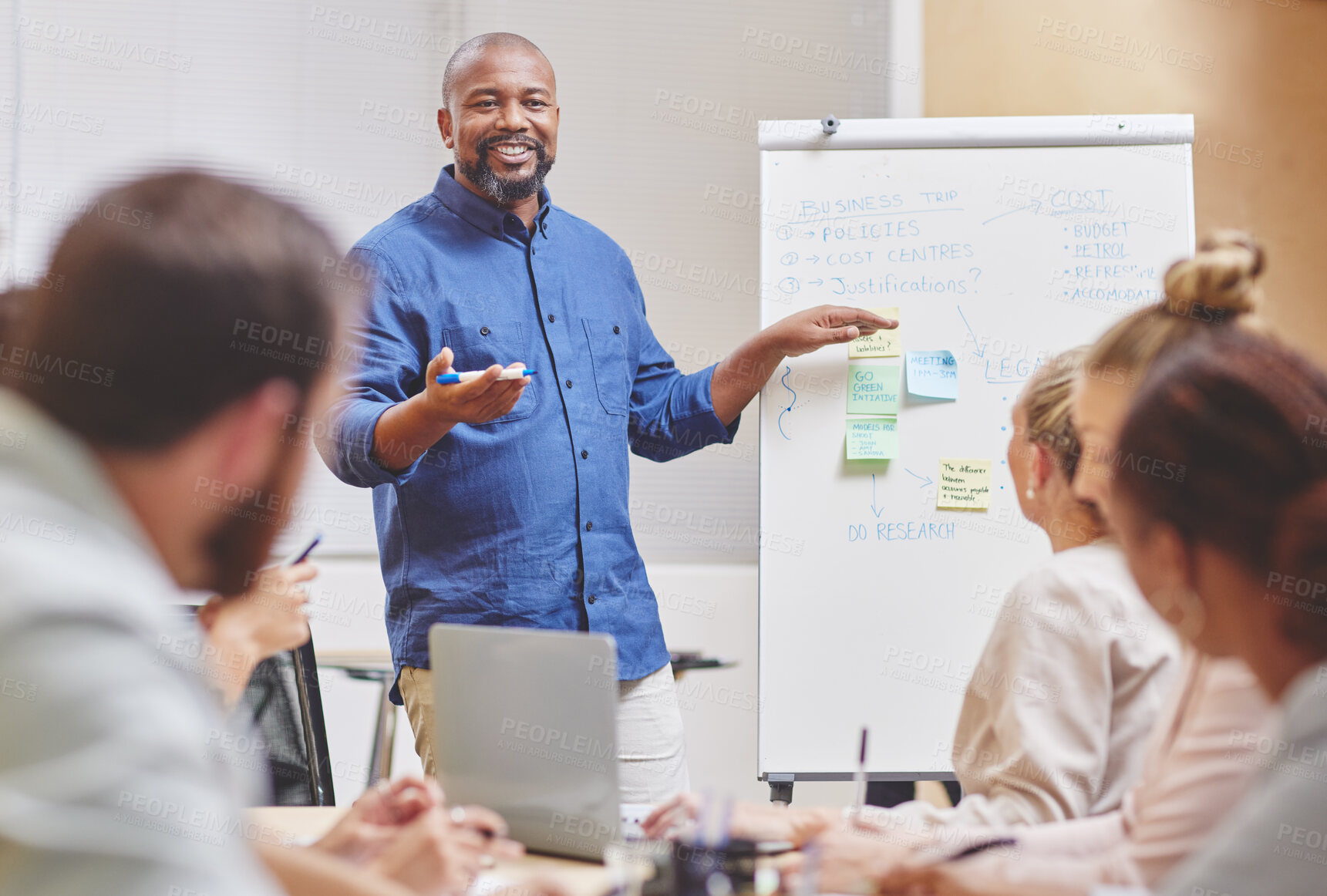 Buy stock photo Black man, coaching and team with whiteboard for presentation, meeting or planning at office. Happy African, mentor or male person talking or explaining to staff or group for business discussion