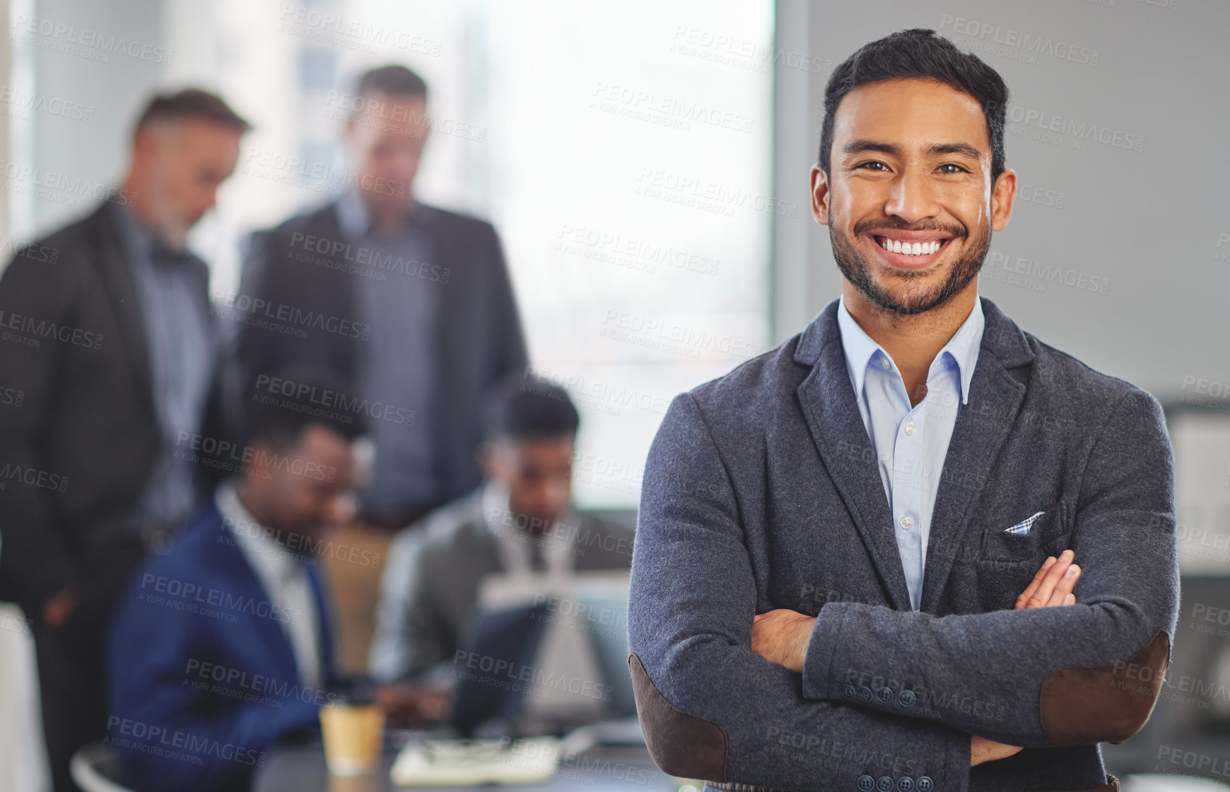 Buy stock photo Portrait of a young businessman at the office standing in front of his colleagues having a meeting in the background