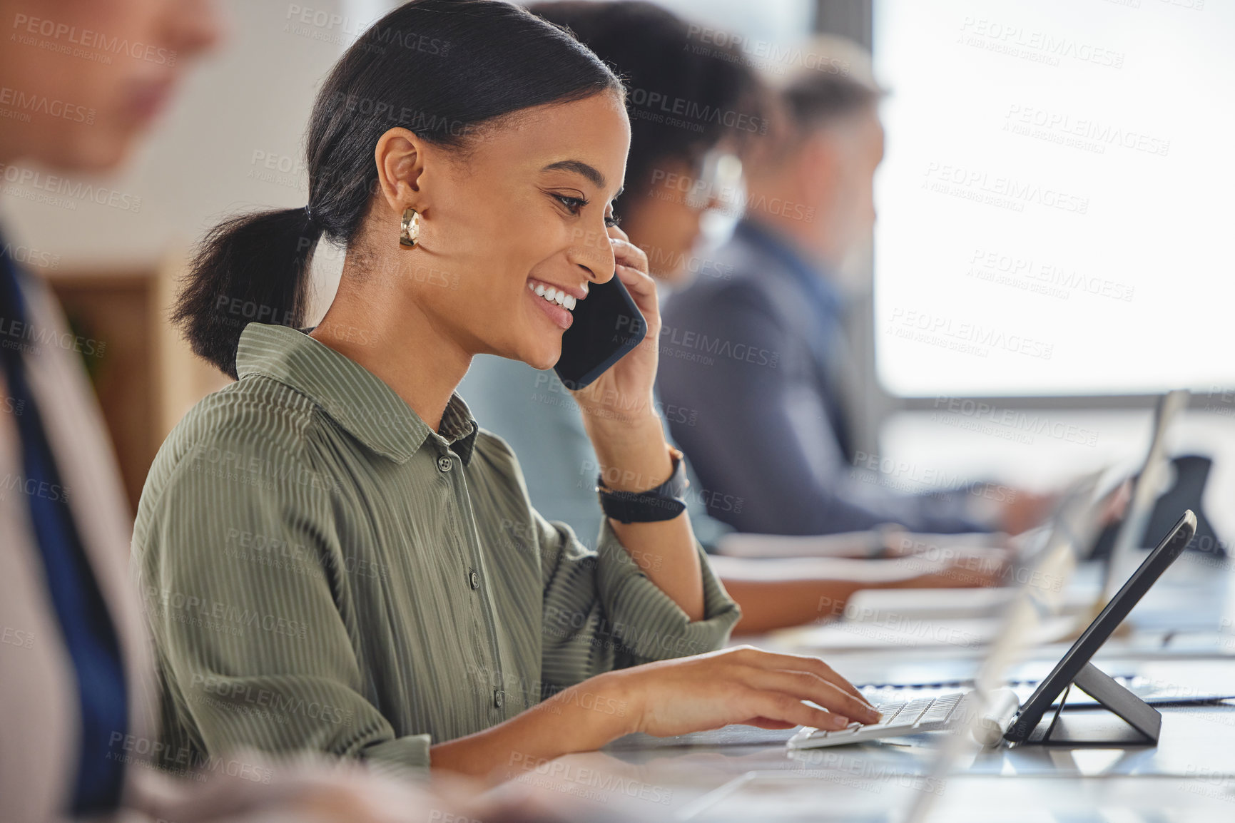 Buy stock photo Shot of a young businesswoman talking on a cellphone while working on a digital tablet in a call centre