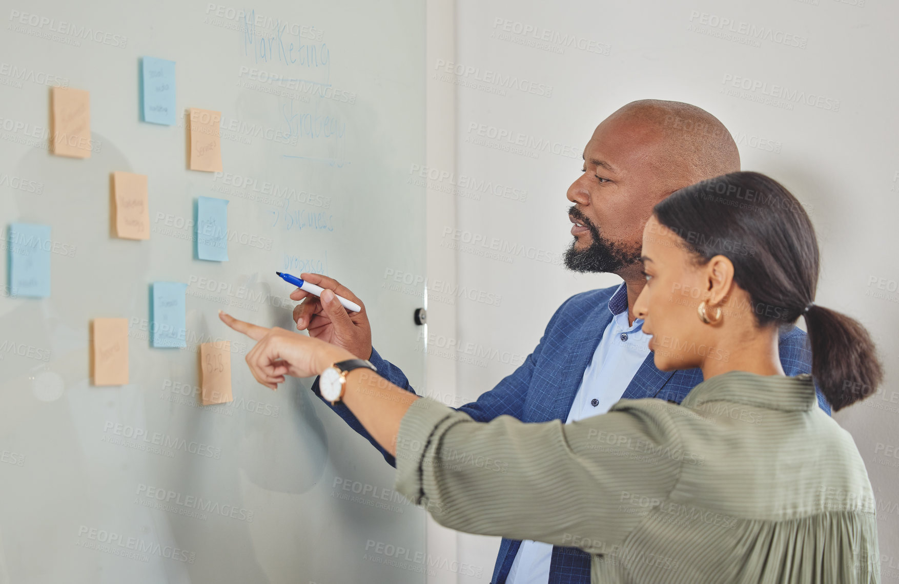 Buy stock photo Shot of two businesspeople brainstorming with notes on a  wall in an office