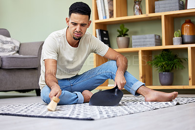 Buy stock photo Man, house and cleaning mess in living room, dust pan and hand broom with spill for cleanliness and hygiene. Accident, housekeeping and maintenance, unhappy and upset and sweeping carpet or dirt