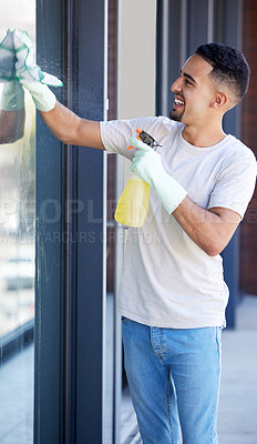 Buy stock photo Shot of a young man washing windows at home