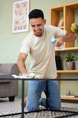 Buy stock photo Shot of a young man cleaning a table at home