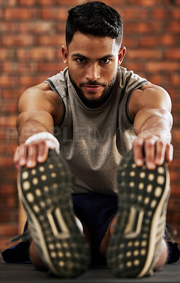 Buy stock photo Gym, portrait of man stretching legs and warm up, workout motivation and fitness mindset with hands on feet. Training, commitment and male athlete on floor, stretch at sports club for exercise goals.