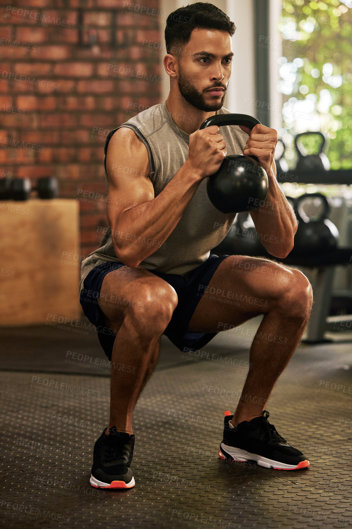 Buy stock photo Squat, fitness and man with kettle bell in gym for exercise, bodybuilder training and workout. Sports, strong muscle and serious male person lifting weight for wellness, healthy body and strength
