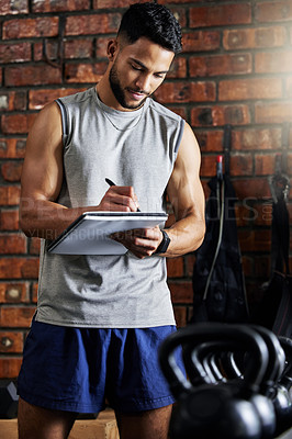 Buy stock photo Shot of a young man doing inventory while working in a gym