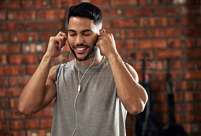 Buy stock photo Fitness, earphones and music, man in gym listening to streaming service for motivation podcast and smile. Exercise, workout and happy bodybuilder, online radio or audio for healthy mindset in club.