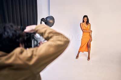 Buy stock photo Shot of a photographer taking photos of a model in a studio