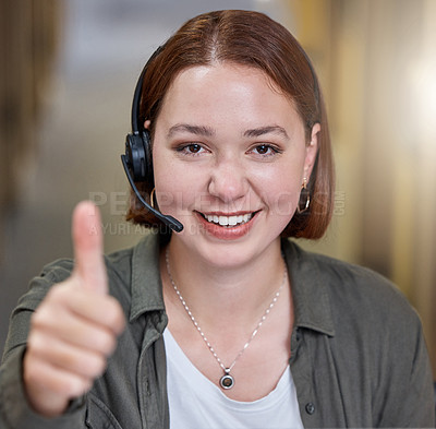 Buy stock photo Shot of a young call centre agent sitting alone in the office and making a thumbs up gesture