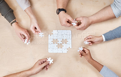 Buy stock photo Puzzle, hands and office group with planning and problem solving at a table. Above, teamwork and company employee team with strategy, collaboration and connection process for decision and solidarity