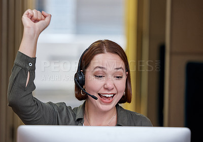 Buy stock photo Shot of a young call centre agent sitting alone in the office and celebrating a success wile using her computer