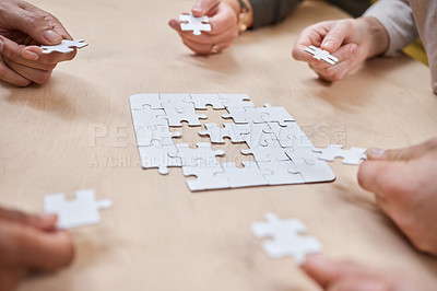 Buy stock photo Cropped shot of an unrecognizable group of businesspeople huddled together and doing a puzzle in the office