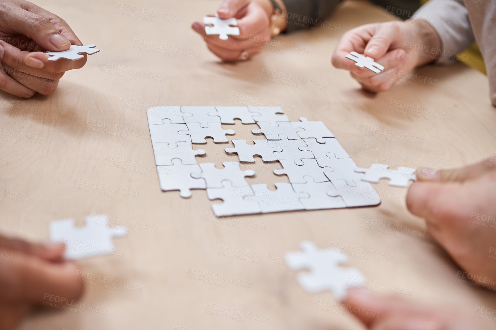 Buy stock photo Cropped shot of an unrecognizable group of businesspeople huddled together and doing a puzzle in the office