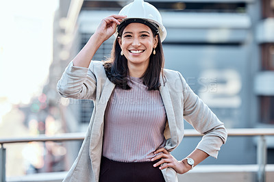 Buy stock photo Shot of a young businesswoman wearing a hardhat while standing outside
