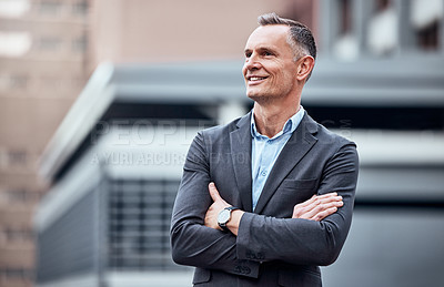 Buy stock photo Shot of a mature businessman standing alone outside with his arms folded