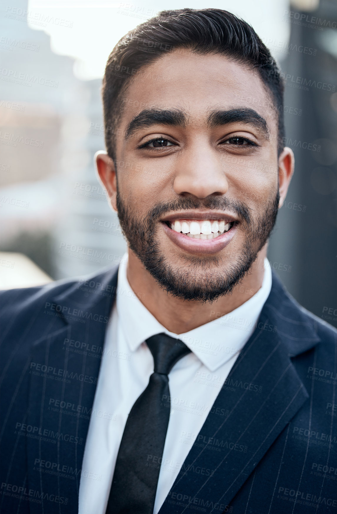 Buy stock photo Shot of a handsome young businessman standing alone outside