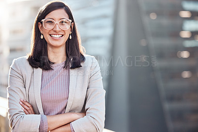 Buy stock photo Shot of an attractive young businesswomen standing alone outside with her arms folded