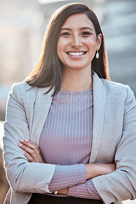 Buy stock photo Shot of an attractive young businesswomen standing alone outside with her arms folded