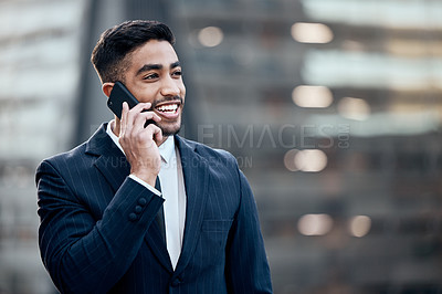 Buy stock photo Shot of a handsome young businessman standing alone outside and using his cellphone