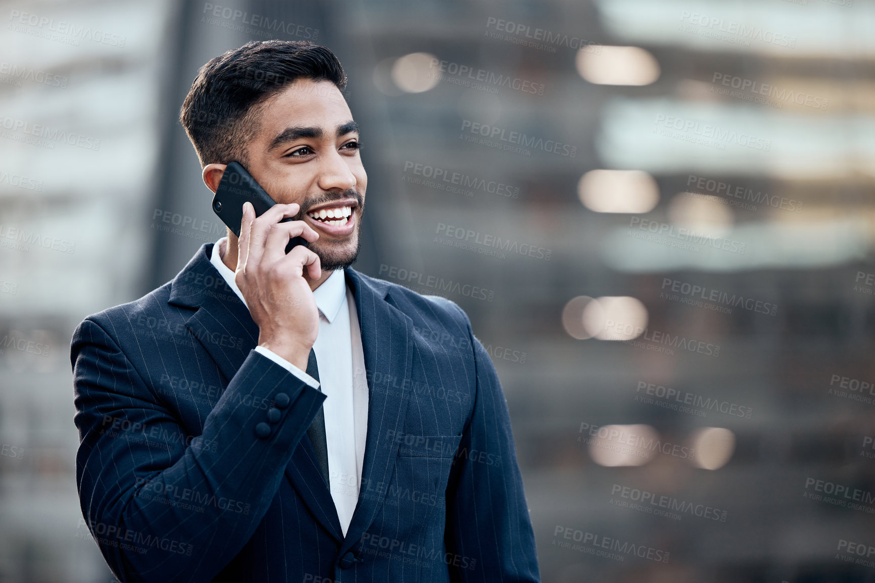 Buy stock photo Shot of a handsome young businessman standing alone outside and using his cellphone