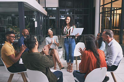 Buy stock photo Shot of a young businesswoman holding her laptop while giving a business presentation