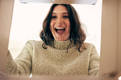 Buy stock photo Shot of a young woman opening a cardboard box at home