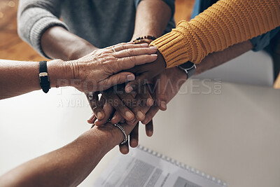 Buy stock photo Shot of a group of unrecognisable businesspeople joining hands together in solidarity inside their office at work