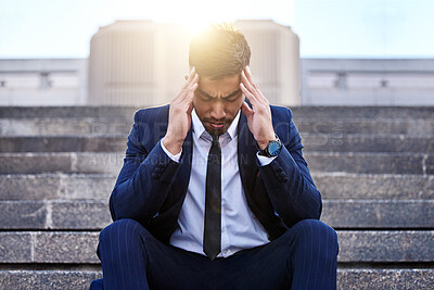 Buy stock photo Shot of a young businessman experiencing a migraine