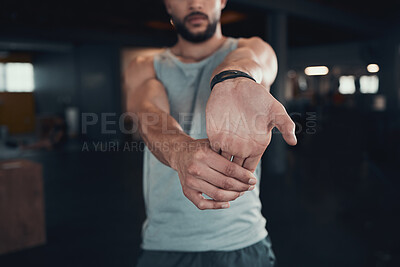 Buy stock photo Shot of a man stretching his hands and arm in the gym