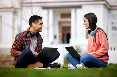 Buy stock photo Shot of two students using their laptops while sitting outside on campus