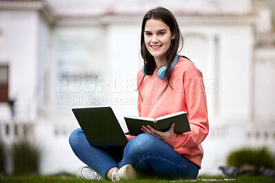 Buy stock photo Shot of a female student using her laptop and notebook while sitting outside