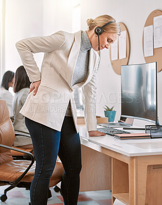 Buy stock photo Cropped shot of an attractive mature female call center agent suffering with back pain while working on her computer in the office