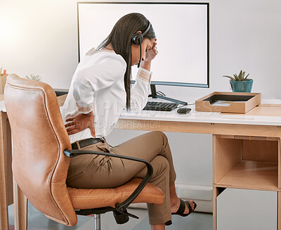 Buy stock photo Rearview shot of a female call center agent suffering with back pain while working on her computer in the office