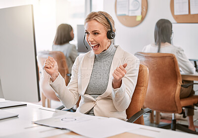 Buy stock photo Cropped shot of an attractive mature call center agent wearing a headset and cheering while working on her computer in the office