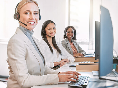 Buy stock photo Cropped portrait of an attractive mature female call center agent wearing a headset while working in the office with her coworkers