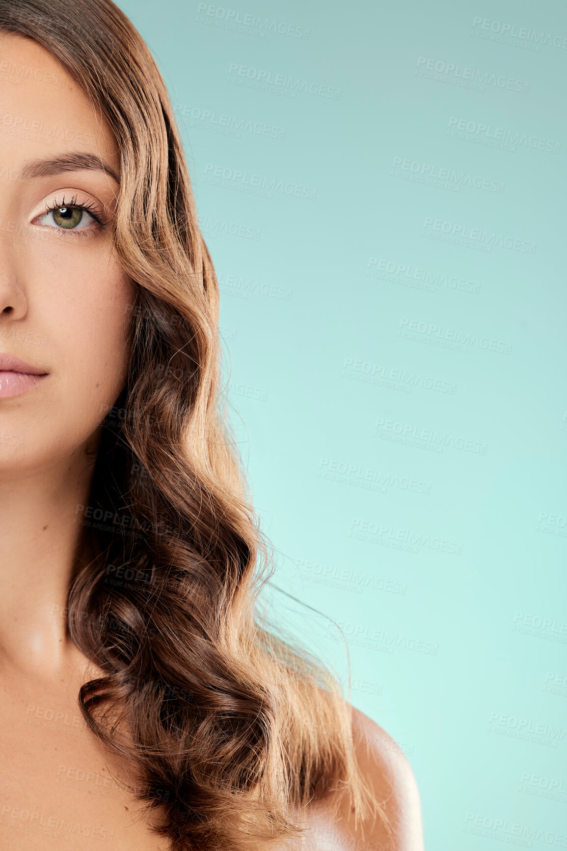 Buy stock photo Woman, portrait and curly hair mockup in studio with space for texture, healthy growth and glow on blue background. Half face, wavy style and shine for salon aesthetic, beauty and keratin results